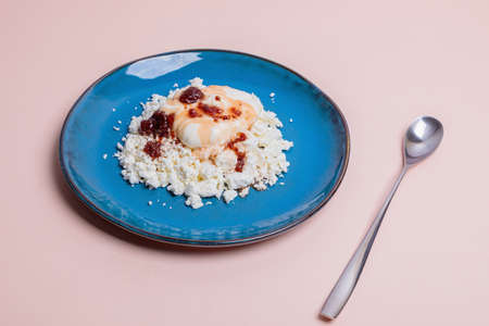 Blue plate with cottage cheese and jam on a pink background.の写真素材