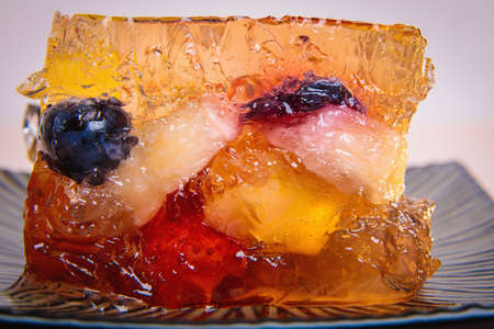 Jelly from different fruits and berries on a square saucer. Dessert.