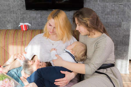 Dad with children congratulate mom on the holiday, mother's day. Have fun, laugh and give flowersの写真素材