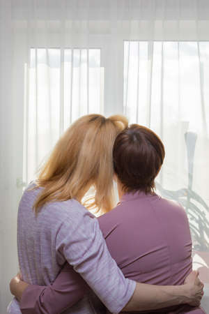 A young girl congratulates her mother on the holiday. Hugs gently and smiles.