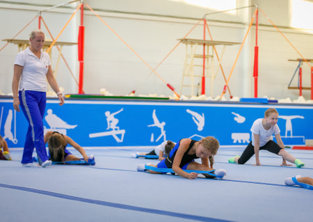 Young athletes perform stretching exercises under the guidance of a coach. Moscow, Russia September 18, 2019のeditorial素材