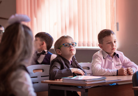 Children sit at their desks in class on September 1. First graders listen carefully to the teacher in the first lesson. Moscow, Russia, September 2, 2019のeditorial素材