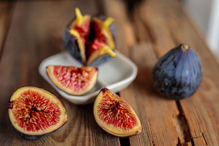 Fresh cut purple figs on a wooden background from old boards. Raw exotic figs.の写真素材