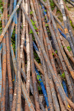 A pile of rusty steel pipes on the ground. Rusty mounting pipes at a construction site.の写真素材