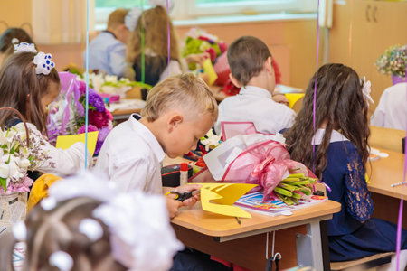 First-graders in the lesson cut out figures for applications from paper. School, Knowledge Day. Moscow, Russia, September 1, 2021のeditorial素材