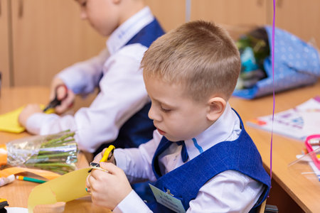 First-graders in the lesson cut out figures for applications from paper. School, Knowledge Day. Moscow, Russia, September 1, 2021のeditorial素材