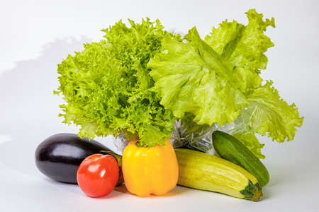 Set of fresh raw vegetables on a white background. Salad, tomatoes, cucumbers, eggplants, zucchini.の写真素材