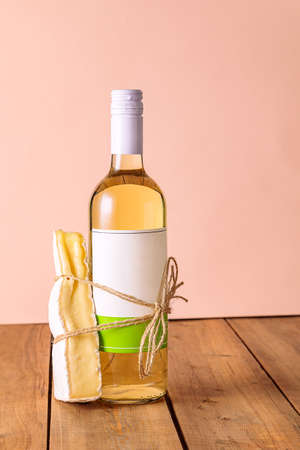 A bottle of white wine with a tied piece of cheese. Suitable food concept, couple. Creativeの写真素材