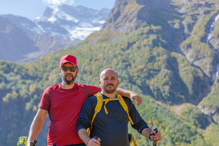 Two tourists are going to climb up the mountain to the waterfalls, inspect the area
