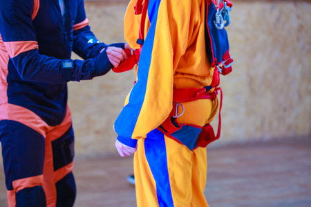 The instructor tightens the straps of the parachute suit. high quality photoの写真素材
