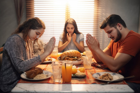 The family gathered around the table prays before eating. high quality photoの素材
