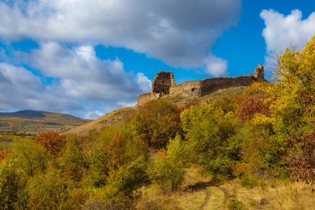 view of a ruined fortress in Ossetia, towering on a hill of a mountainの写真素材