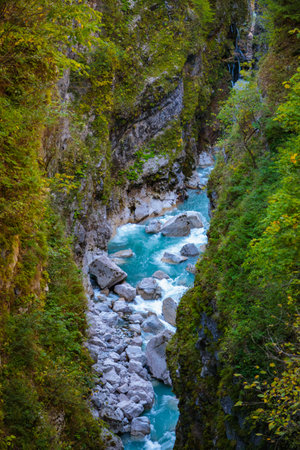 A mountain gorge with a fast flowing river, surrounded by high cliffs and beautiful natureの写真素材