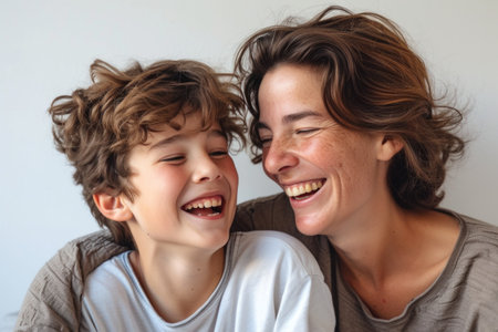A woman and a boy are displaying bright smiles for the camera, showing their happy facial expressions. Their noses, hair, skin, and eyelashes are also highlighted in the photoの素材