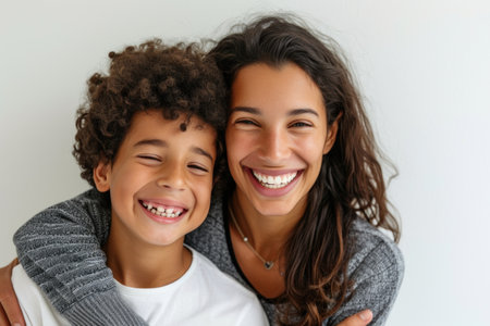 A woman and a boy are sharing a happy embrace, smiling for the camera with a gesture of love. This joyful moment captures the essence of fun and leisure while traveling togetherの素材