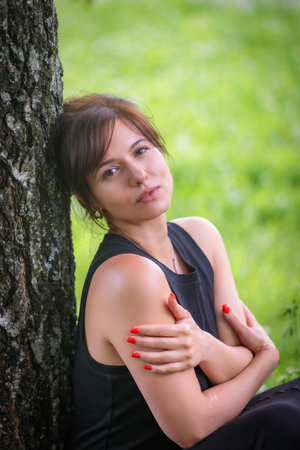 The womans gaze is full of emotions among the birch grove, creating a magical picture of nature and femininityの写真素材
