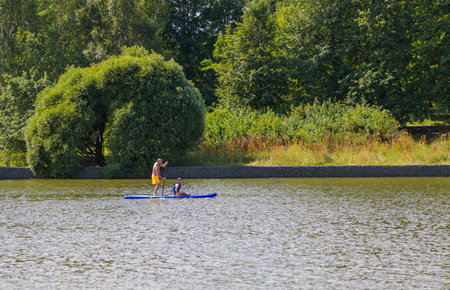 A family adventure: father and son have fun, ride a SUP board together.の写真素材