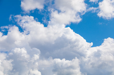 A picturesque idyllic landscape: a clear azure sky is strewn with cumulus clouds, creating an atmosphere of tranquility and beautyの写真素材