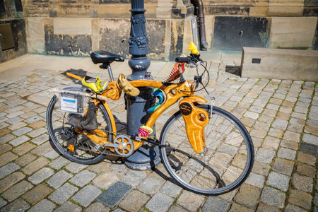 Wooden bicycle with unusual design parked near a lamppost on a cobblestone streetの写真素材