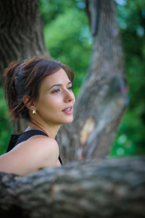 Portrait of a sophisticated lady surrounded by greenery and natural beauty in an elegant park landscapeの写真素材