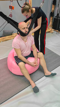 Physiotherapist assisting patient with neck traction therapyの写真素材