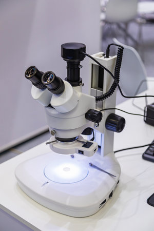 Modern microscope illuminating sample in laboratory settingの写真素材