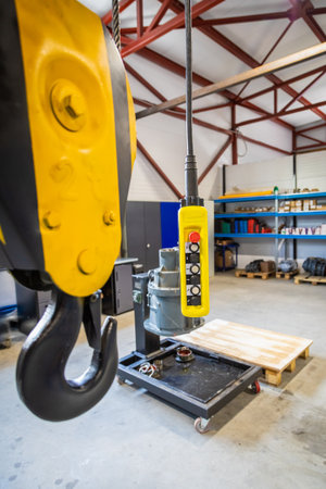Close up of an overhead crane remote control hanging in a factory, ready to operate lifting machineryの写真素材