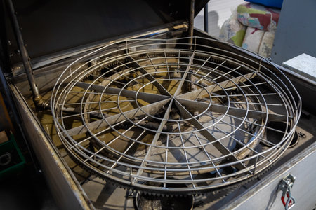 Metal parts being cleaned in an industrial parts washer with a rotating basket, ensuring thorough degreasing and contaminant removalの写真素材