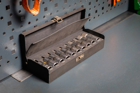 Socket set for mechanic tools lying inside an open box on a workbench in a workshop, ready to be usedの写真素材