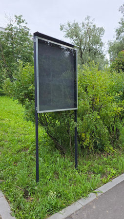 Empty bulletin board stands in a green park, ready for displaying announcements and community informationの写真素材