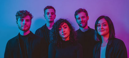 Group of five young adults posing together against a vibrant purple and blue backdrop, highlighting their unique hairstyles and friendly expressionsの素材