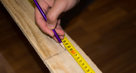 Closeup of a man hand that making a mark on timber with pencilの写真素材