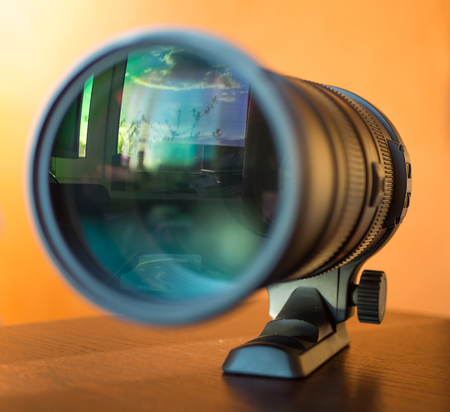 Blue sky with clouds reflecting in telephoto lens