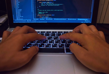 Hacker breaching the secure system in cyberspace, hands on keyboardの写真素材