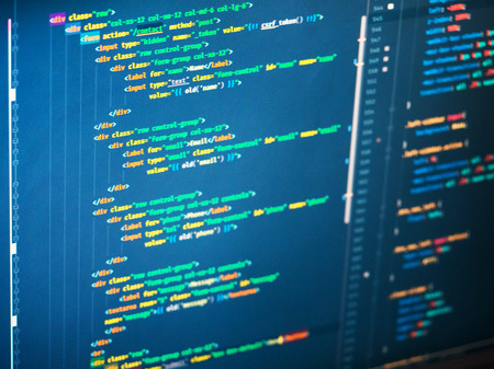 Web programming code on blue background on the screen, close up