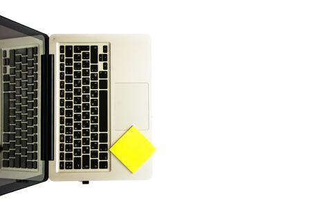 Keyboard of laptop and empty yellow sticker for notes isolated on the white background. Flat lay, Copyspaceの写真素材