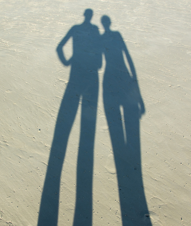 Shadow of man and woman on a sandの写真素材