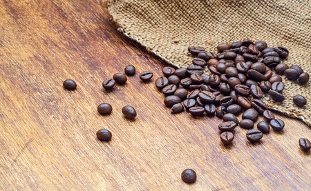 Coffee beans on wood and bagging background, macro,