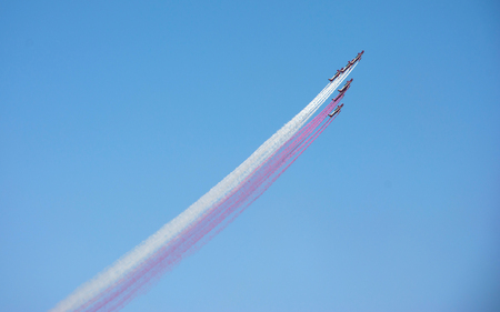Colored line on blue sky made by training plane in airshowの写真素材