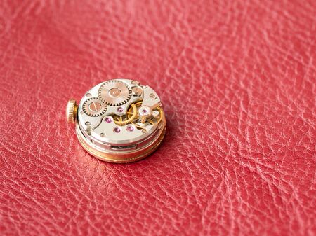 Macro shot of watch mechanism on red background. Place for textの写真素材