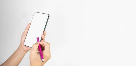 Close-up of hand holding smartphone with pen isolated on white background with space for your text.の写真素材