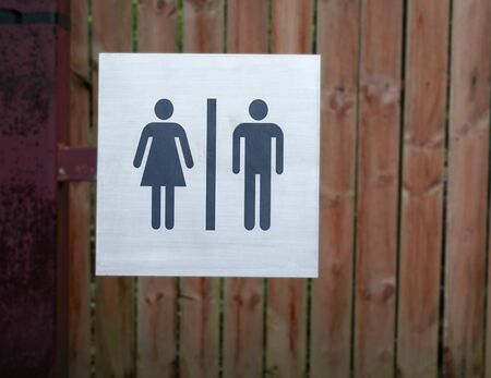 Restroom sign, a lady and a man on wood background at public toilet.の写真素材