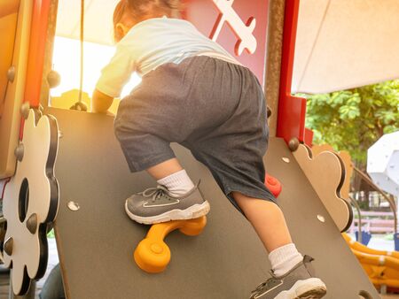Asian little child girl climbing to slide at playground.の写真素材
