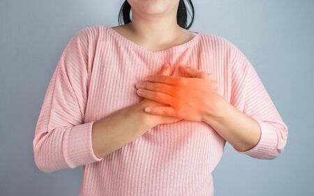 Asian young woman suffering from chest pain caused by heart disease.の写真素材