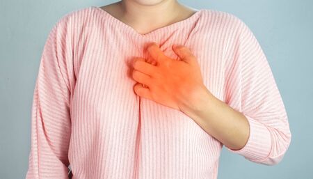 Asian young woman suffering from chest pain caused by heart disease.の写真素材