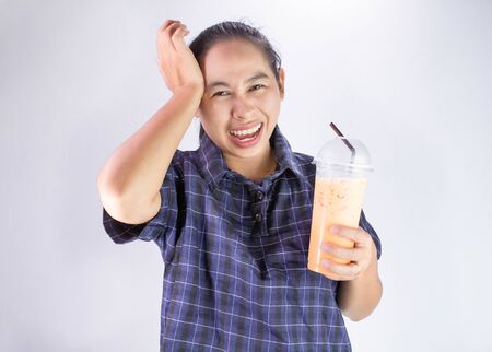 Asian young woman touching head with hand because she Brain freeze from drinking cold water. Health care concept.の写真素材