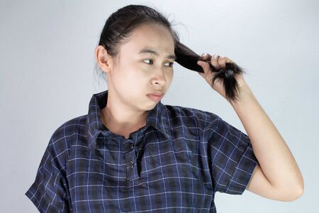 Portrait of Asian young woman with ends of long hair care problems; dry hair and split ends. Treatment and Hair care concept.の写真素材