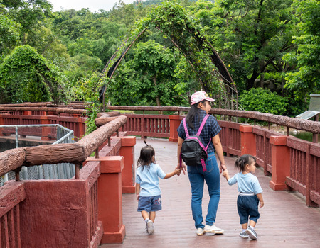 24 August 2019- Chiang Mai,Thailand ; Happy Asian family holding hands and walking together on the bridge to look animals in the Night safari.のeditorial素材