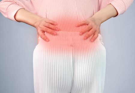Woman suffering from back pain after work hard at home. Health care concept.の写真素材