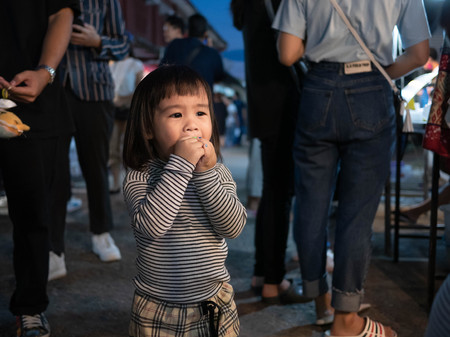 Lampang, Thailand; 5 October 2019 - Adorable Asian child girl having fun with Dracula teeth plastic toys in Kad Kong Ta Walking Street.のeditorial素材